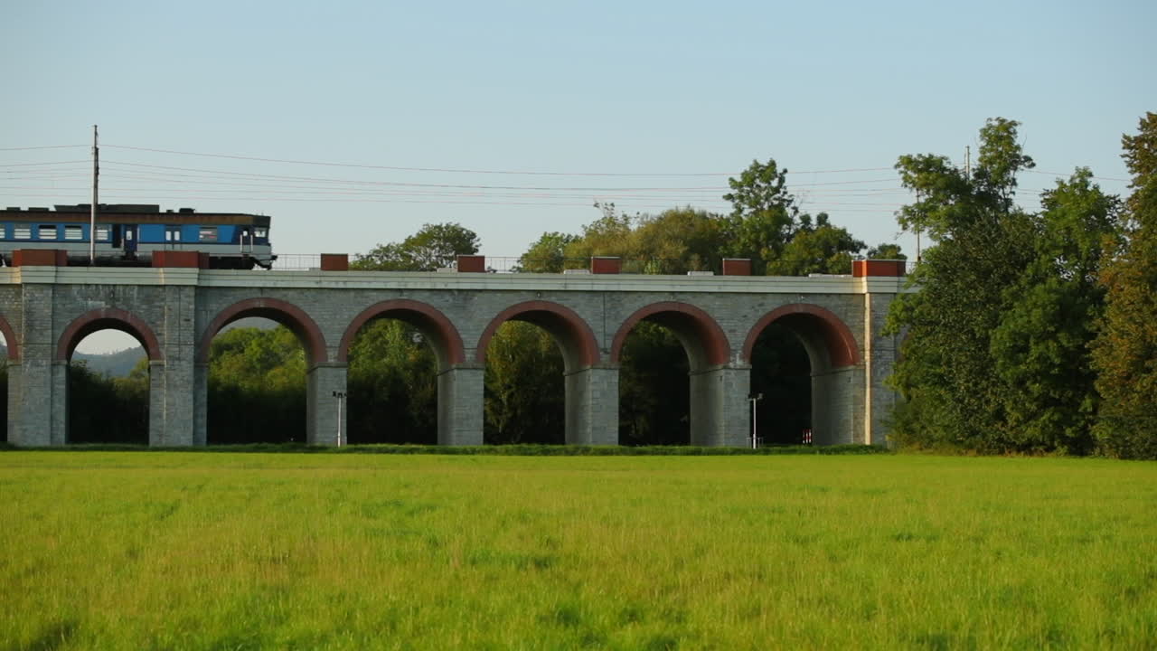 지나가는 여객 열차가 다리를 건너는 슬로우 모션 철도 고가교