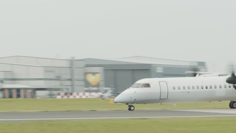 a twin propeller plane takes off from a runway