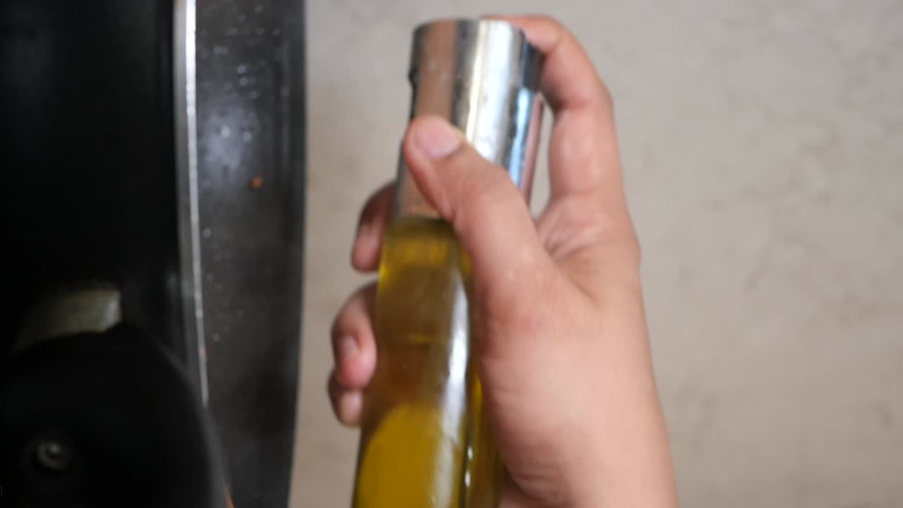 vertiendo aceite en una sartén