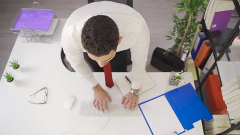 joven hombre de negocios concentrado está trabajando en la oficina mirando la computadora.