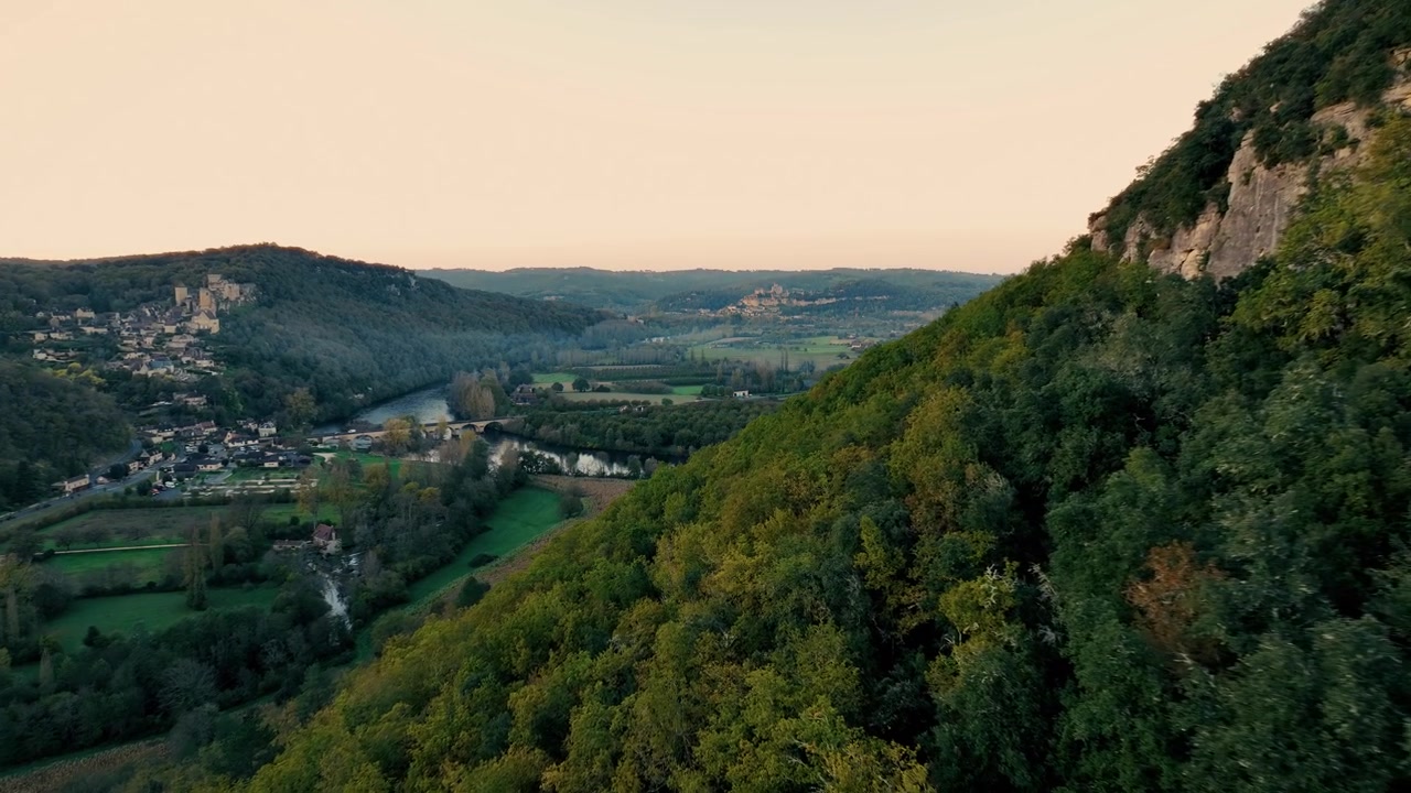 Castello di Castelnaud ripreso da drone in una foresta con scogliere vicine al tramonto, villaggio medievale vicino a Sarlat La Caneda