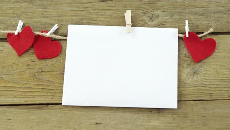 red hearts and envelope with cloth peg hanging on rope