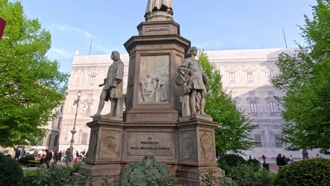 a statue surrounded by greenery and people