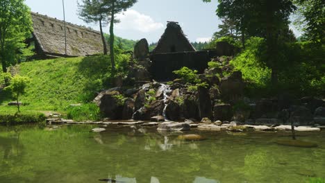 Hermosa-Roca-Con-Agua-Corriendo-Hacia-El-Estanque-En-Shirakawago