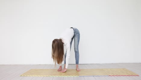 woman stretching and bending forward on a mat
