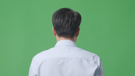 스튜디오에서 녹색 스크린 배경에서 는 아시아 사업가의 뒷면 클로즈업
