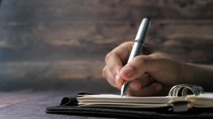 Hand Writing in a Notebook