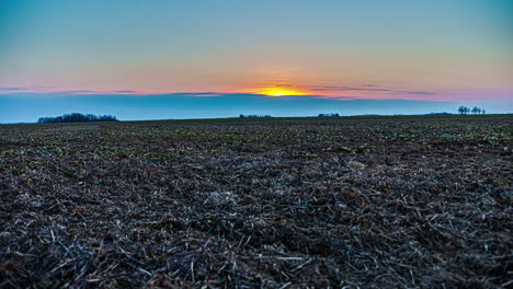 lapso de tiempo del amanecer sobre un campo cosechado de cultivos agrícolas