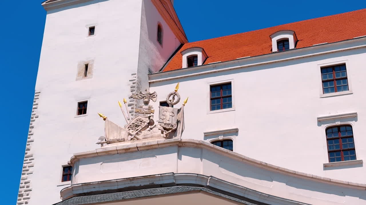 Bratislava, Slovakia, 2 June 2025: Heraldic emblem featuring a crown, an eagle, spears and flags. Decorative motive ornamenting the Bratislava Castle, Slovakia
