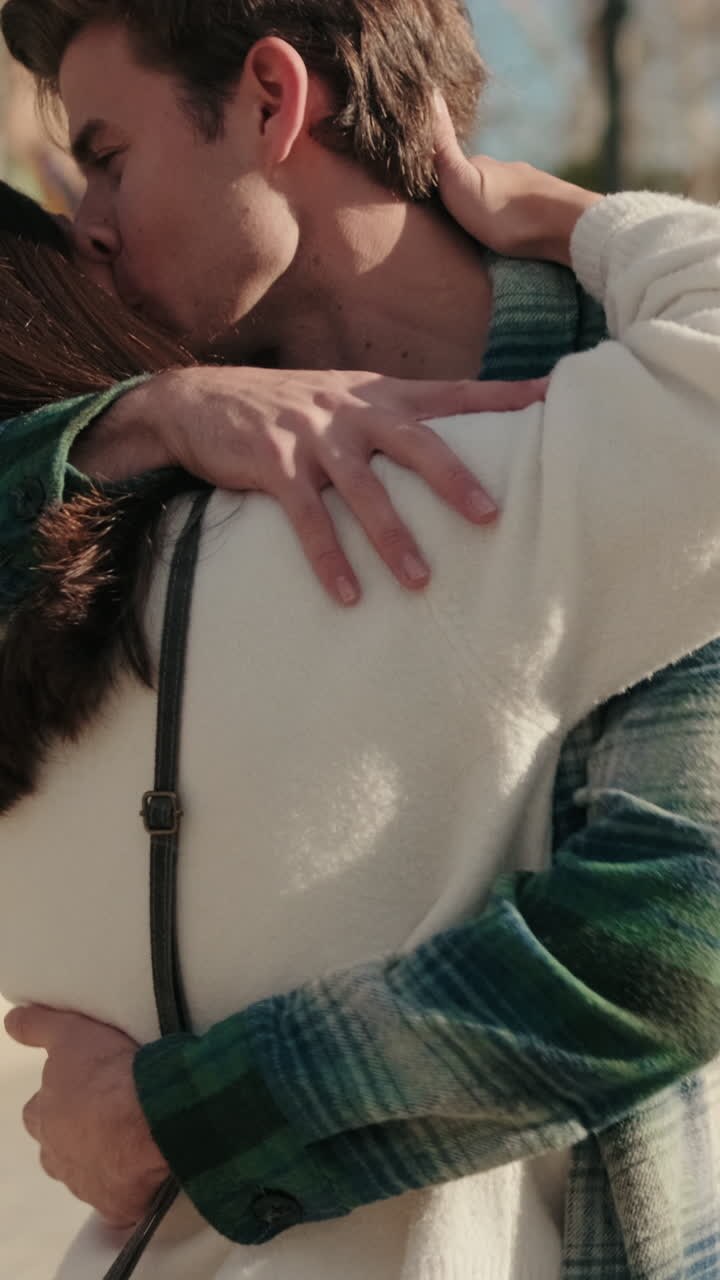 Young loving couple meet on the street, hug and kiss