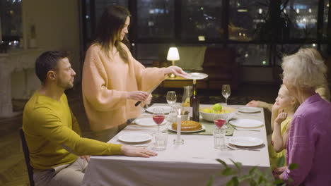 woman serving pie to her family during a dinner at home