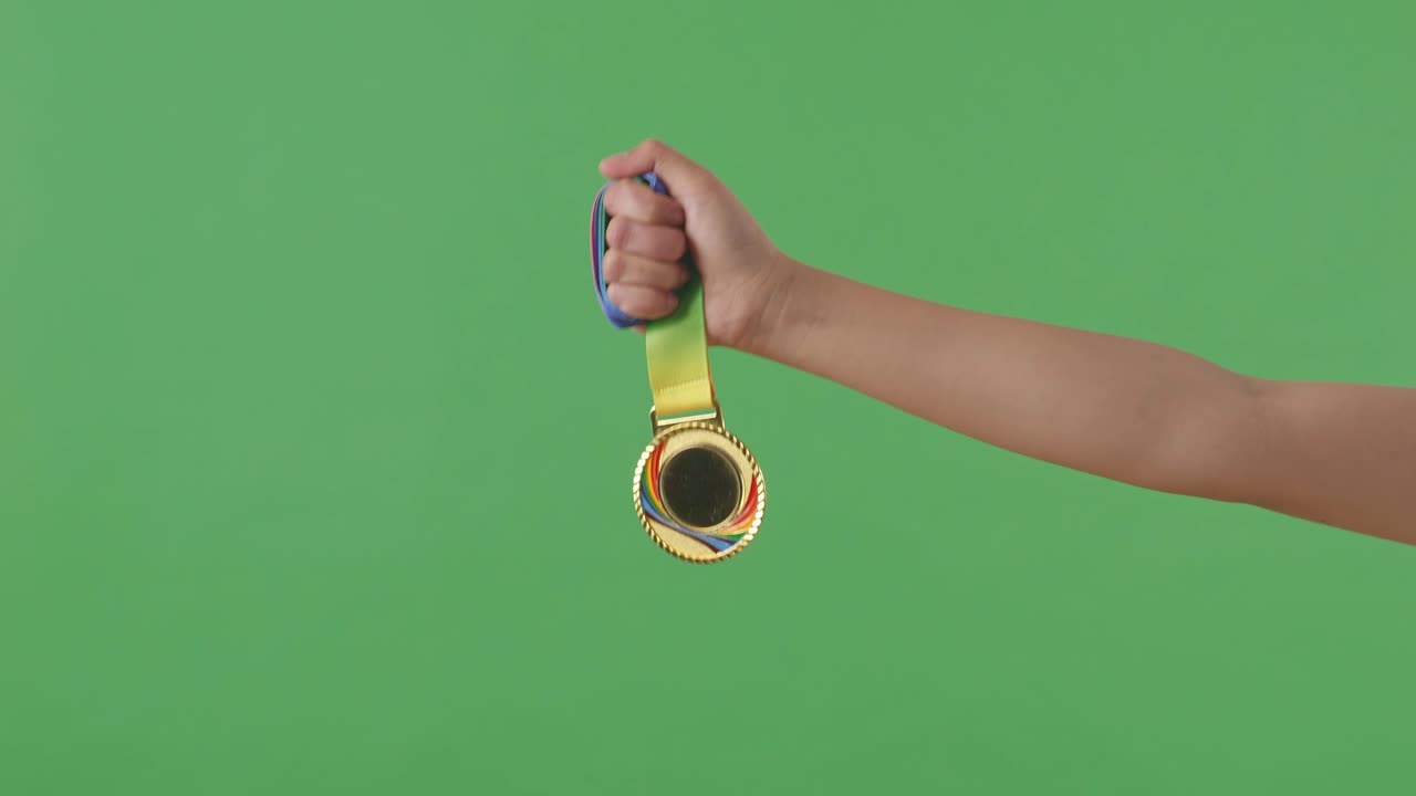 Golden Medal In Hand. Green Screen Background