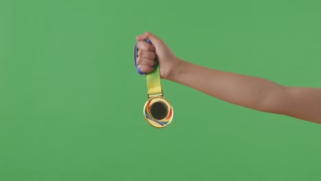 medalla de oro en la mano. fondo de pantalla verde