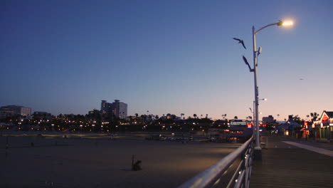 Handaufnahme-Des-Strandes-Von-Santa-Monica-Vom-Pier-Aus,-Wenn-Die-Nacht-Hereinbricht