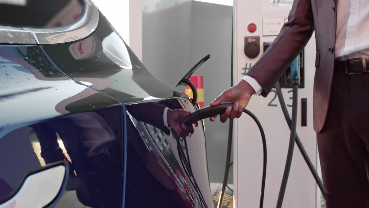 Unrecognizable businessman connecting an electric car from a charging station the senior connects