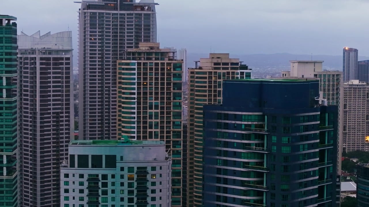 Vuelo con teleobjetivo revela densos rascacielos bajo la lluvia gris en la ciudad de Makati