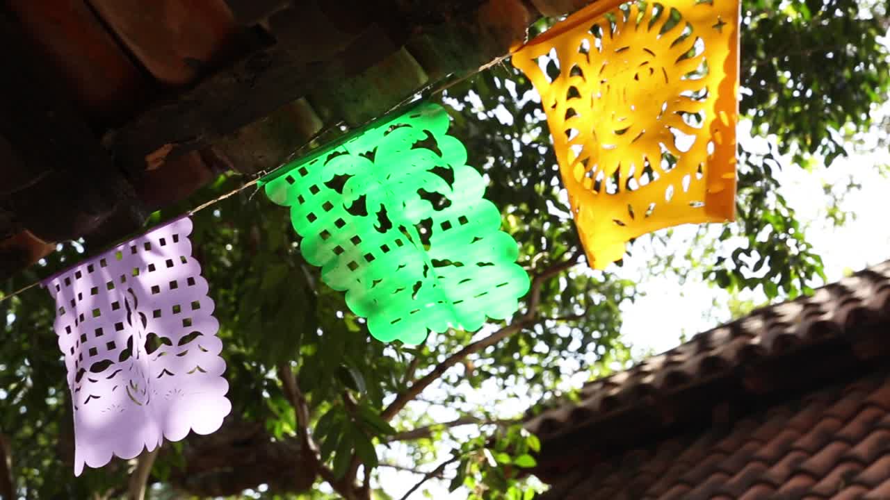 Traditional Mexican plastic pennants hanging from a string in vibran colors