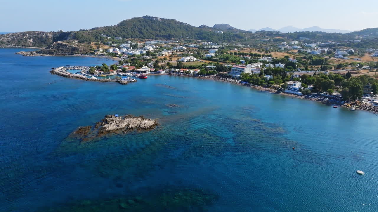 Establishing drone shot toward the Faliraki harbor, in sunny Rhodes, Greece