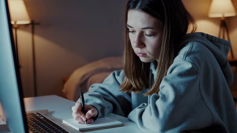 una mujer joven estudiando hasta tarde en la noche.