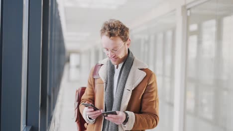 A-man-standing-in-the-hallway-makes-an-online-purchase-with-a-credit-card