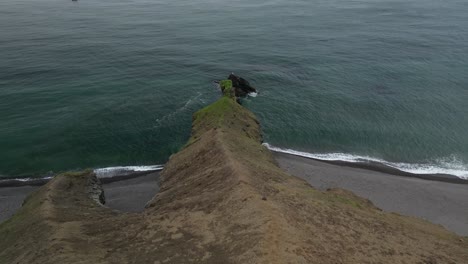 Ein-Steiler-Erdrutsch-Trifft-Auf-Das-Meer-Und-überquert-Einen-Schwarzen-Sandstrand-Im-Südosten-Islands