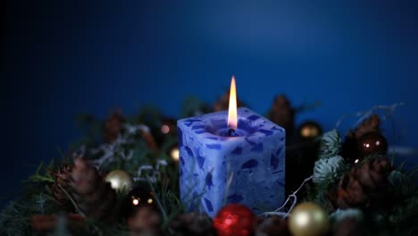 a lit blue candle was spinning in a christmas wreath