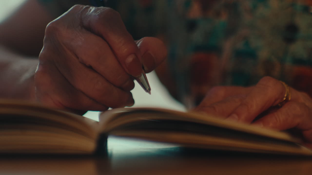 cerca de la mujer mayor mano vieja sosteniendo pluma de tinta y escribiendo notas ideas creativas pensamientos en el diario de cuadernos