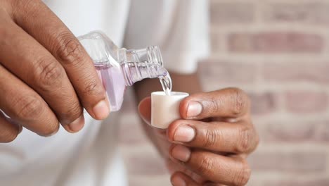 hand hold a mouthwash liquid container
