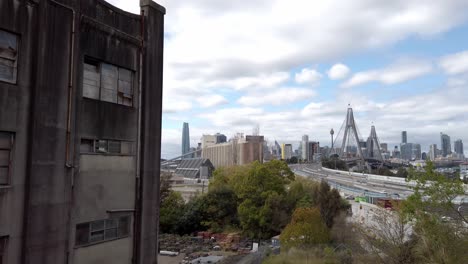 Äußeres-Des-Verlassenen-Gebäudes-Des-Balmain-Kraftwerks-In-Sydney,-NSW-Mit-Anzac-Brücke-Im-Hintergrund-Tagsüber