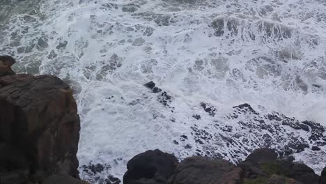 waves swell and crash against the rocks, high angle