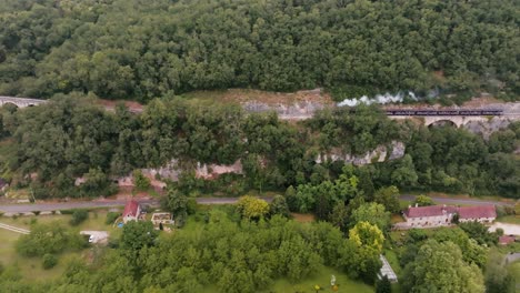 Ein-Kleiner-Dampfzug-An-Einer-Klippe-Bewegt-Sich-Langsam-Vorwärts-Und-Befördert-Touristen-Durch-Die-Französische-Landschaft,-In-Der-Nähe-Von-Martel-In-The-Lot,-Frankreich