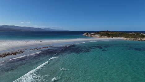 waves of turquoise indian ocean reaching sandy beach in tasmania