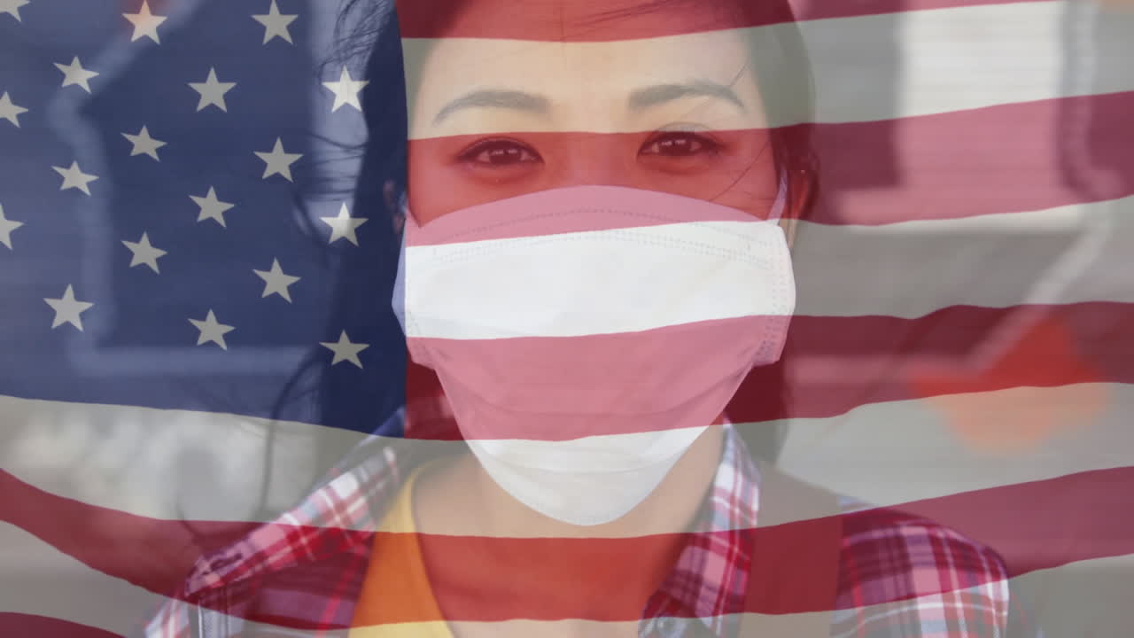 길거리에서 얼굴 마스크를 쓴 아시아 여성의 초상화에 대항하여 미국 국기를 흔들고 있습니다.
