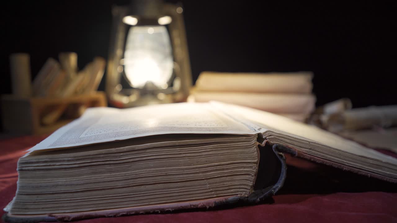 un libro de historia desgastado de la antigüedad, leyendo con una lámpara de queroseno.