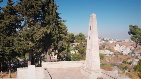 stone monument on hilltop overlooking a city landscape