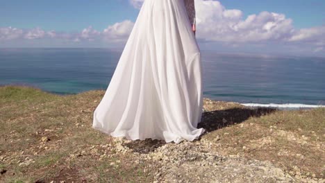 Pretty-young-bride-on-cliff-white-dress-fluttering-in-the-wind