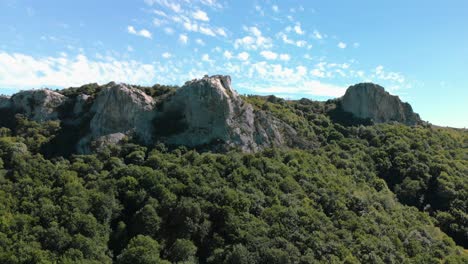 Drone-is-climbing-up-over-a-forest-to-the-rocks-on-the-top,-Kotel,-Bulgaria---October-15th,-2018