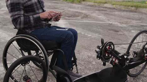 disabled man on his touch pad after assembling parts of a bicycle