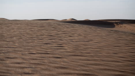 arena en cámara lenta soplando en un desierto