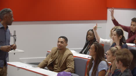 male teacher with university students in lecture theatre