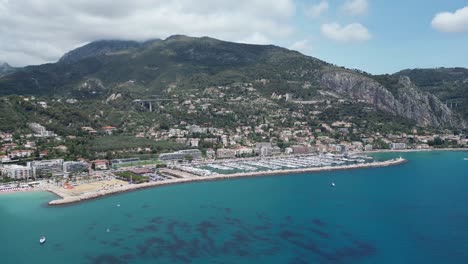 acercándose a la marina de barcos en la ciudad costera de menton en el sur de francia, dolly aéreo en la toma