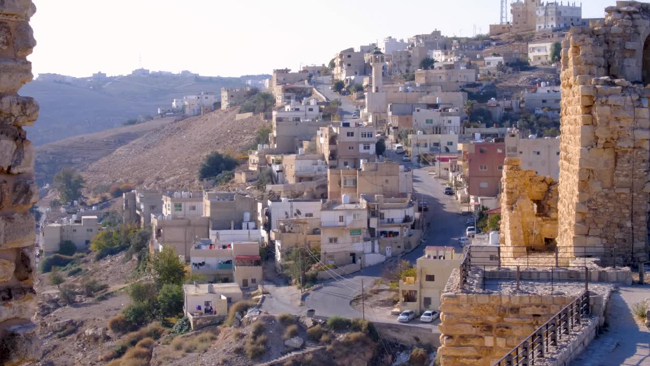 Veduta della città di case e appartamenti densamente raggruppati e dello storico Castello Medievale di Kerak ad Al-Karak, Giordania, Medio Oriente.