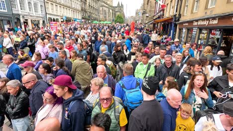 large crowd gathers on cockburn street, edinburgh