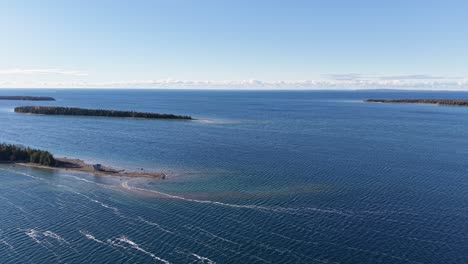 aerial view of deep blue lake with islands and sandbars stretching toward the horizon on a clear day