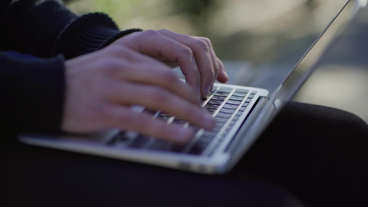 Mani maschili che digitano sulla tastiera di un laptop