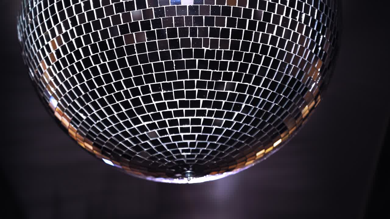 Palla da discoteca con raggi luminosi. Primo piano di una colorata luce a palla da discoteca appesa al soffitto.