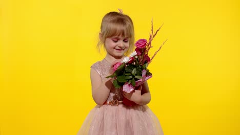 Little-child-girl-with-fashion-makeup-standing-with-bouquet-of-flowers-isolated-on-yellow-background