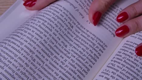 woman reading a book with red nails