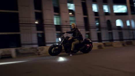 male rider circling around on a his motobike on the city street road at night