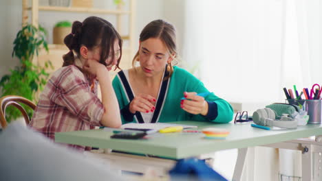 la madre apoya a su hija en hacer sus tareas para la escuela